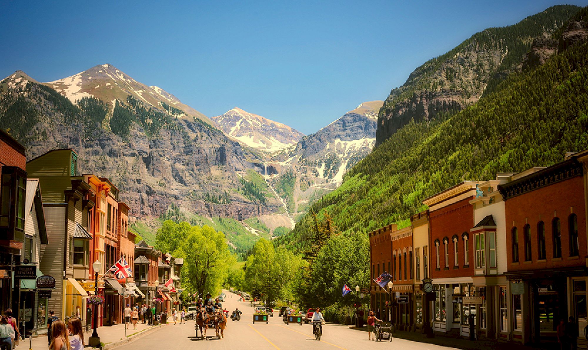 A charming Colorado mountain town with colorful buildings and a backdrop of snow-capped peaks.