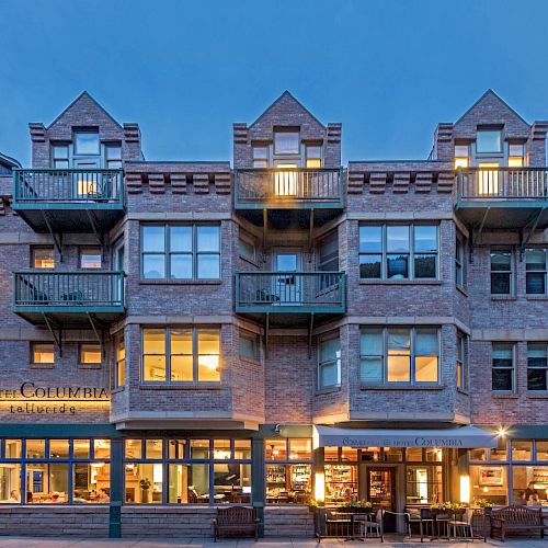 Hotel Columbia Telluride at dusk with lit interiors and balconies.