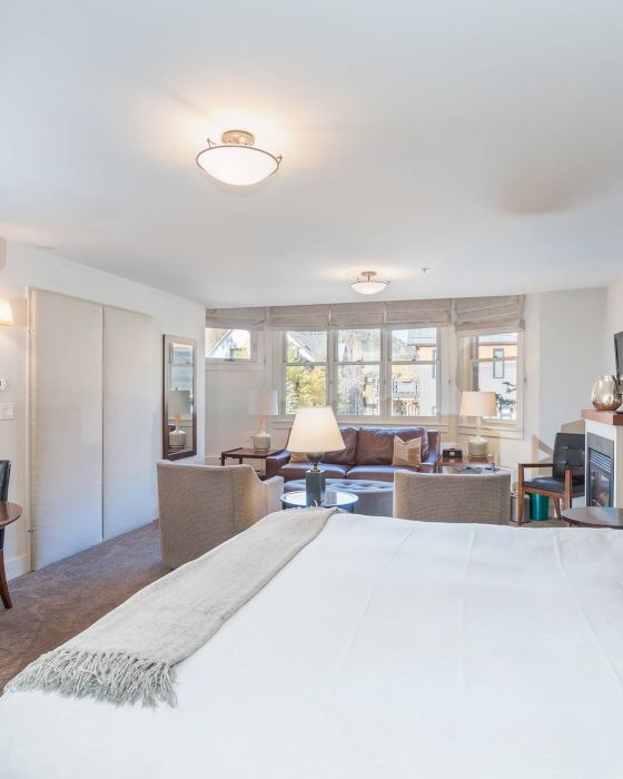 A neatly arranged Hotel Columbia Telluride room with a large bed, artwork, and seating area.
