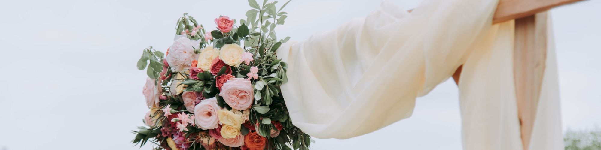 A beautiful floral arrangement attached to a wedding arch outdoors in Hotel Columbia Telluride.