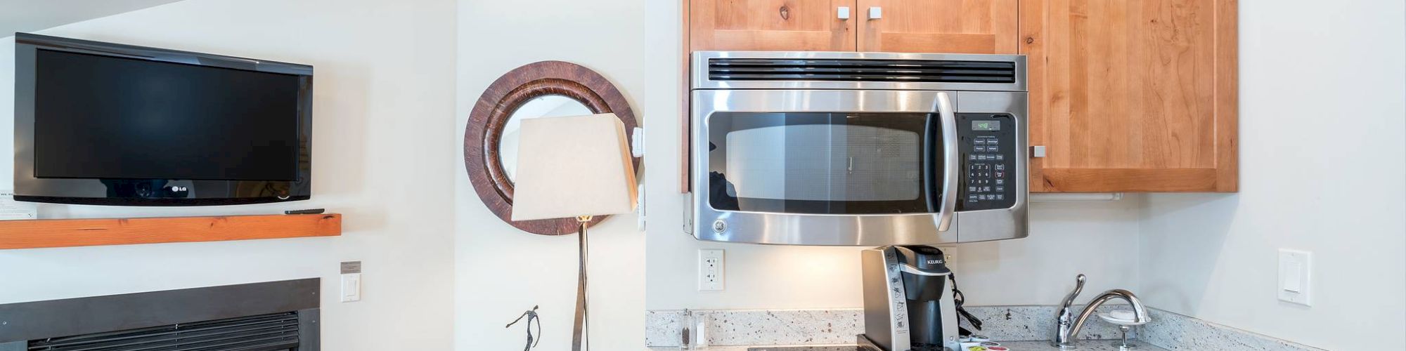 A cozy kitchen with wood cabinets, granite countertop, microwave, stove, TV, and a fireplace.