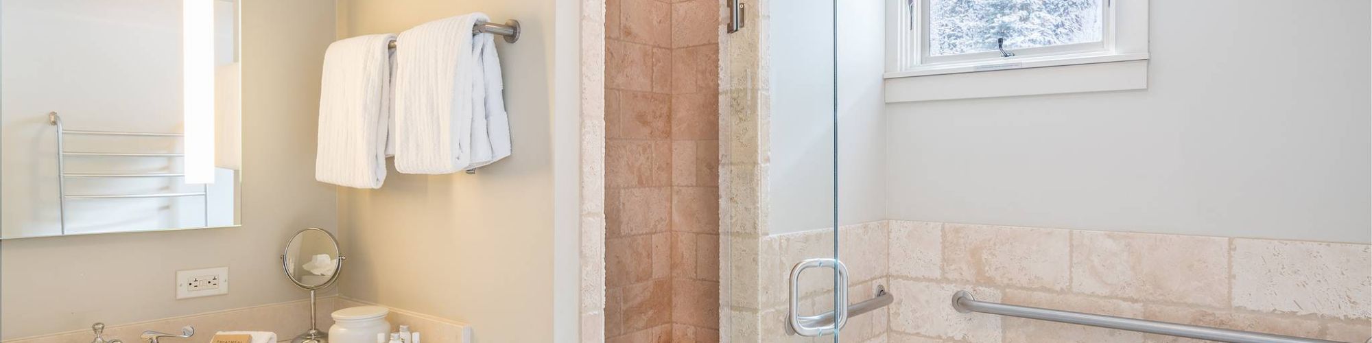 A clean, modern bathroom with a tub, shower stall, sink, and towels.