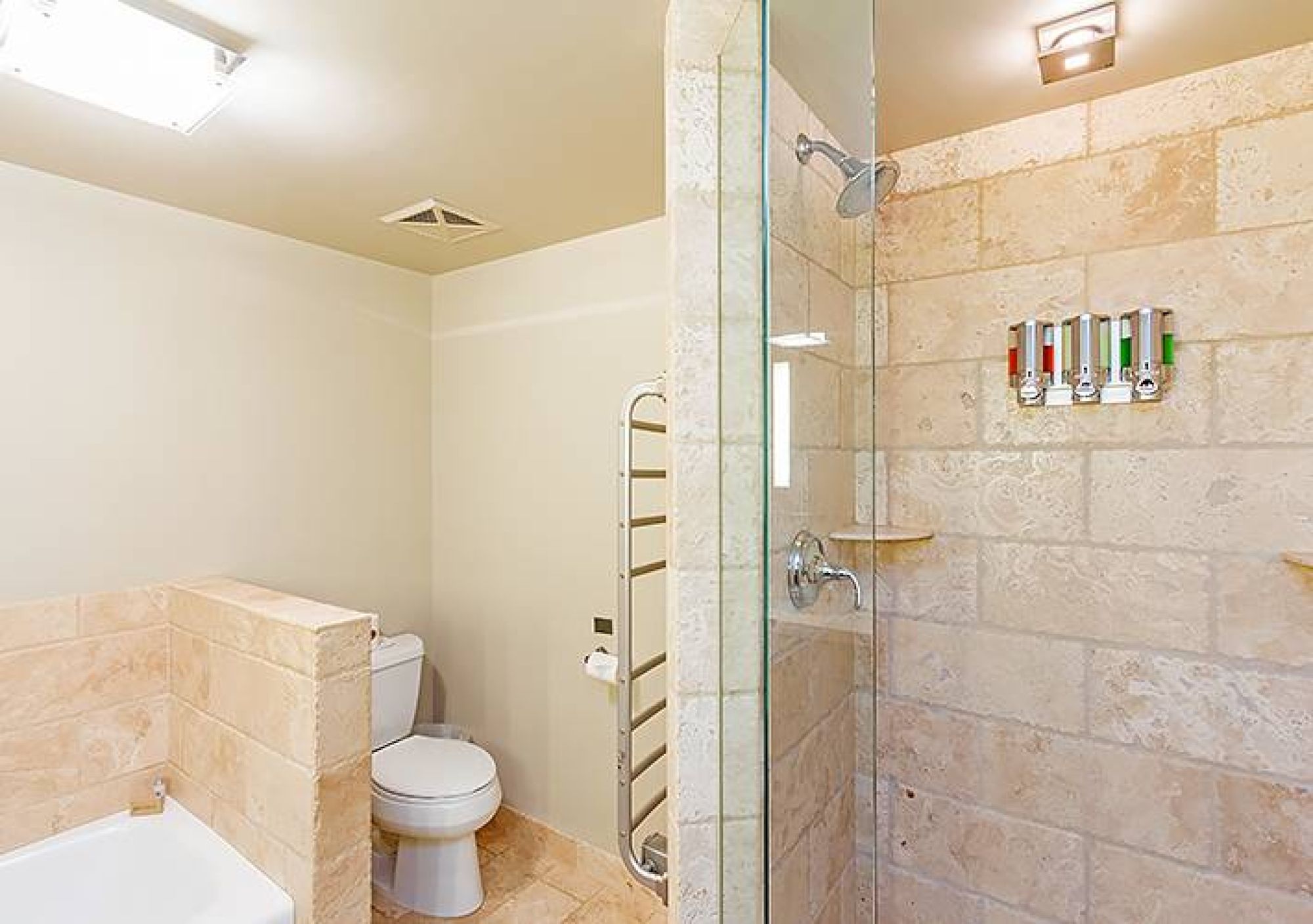 Modern bathroom with a shower, toilet, and toiletries on the wall.