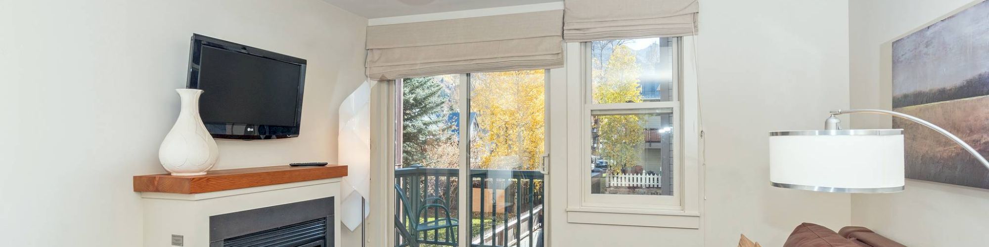 A cozy Hotel Columbia Telluride with a sofa, fireplace, TV, and a window with a view.