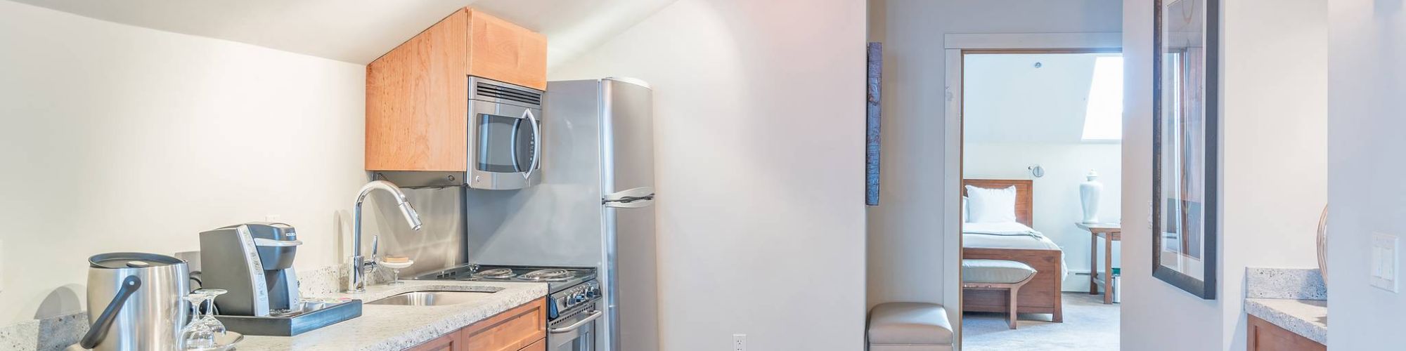 Modern kitchen interior with wooden cabinets, appliances, and a dining area.