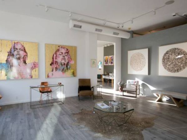 An art gallery with paintings, furniture, and a relaxed ambiance.