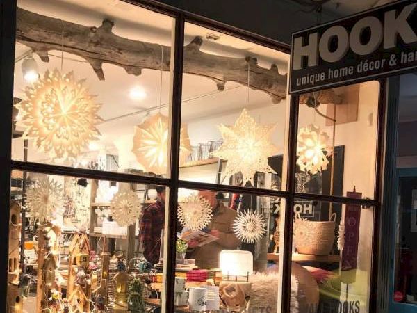A shop window at night, displaying decorative items and lights with the name "HOOK" overhead.