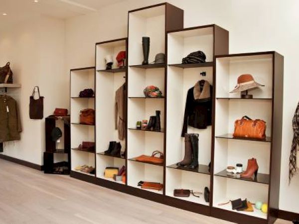 A boutique interior with clothes, shelves of bags, hats, and shoes.