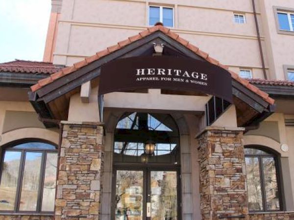 The image shows a building entrance with the name "Heritage" and stone accents.
