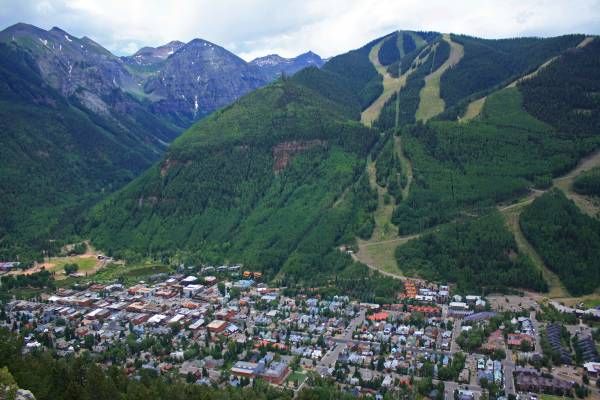 Aerial view of a mountain town with ski slopes in the background.