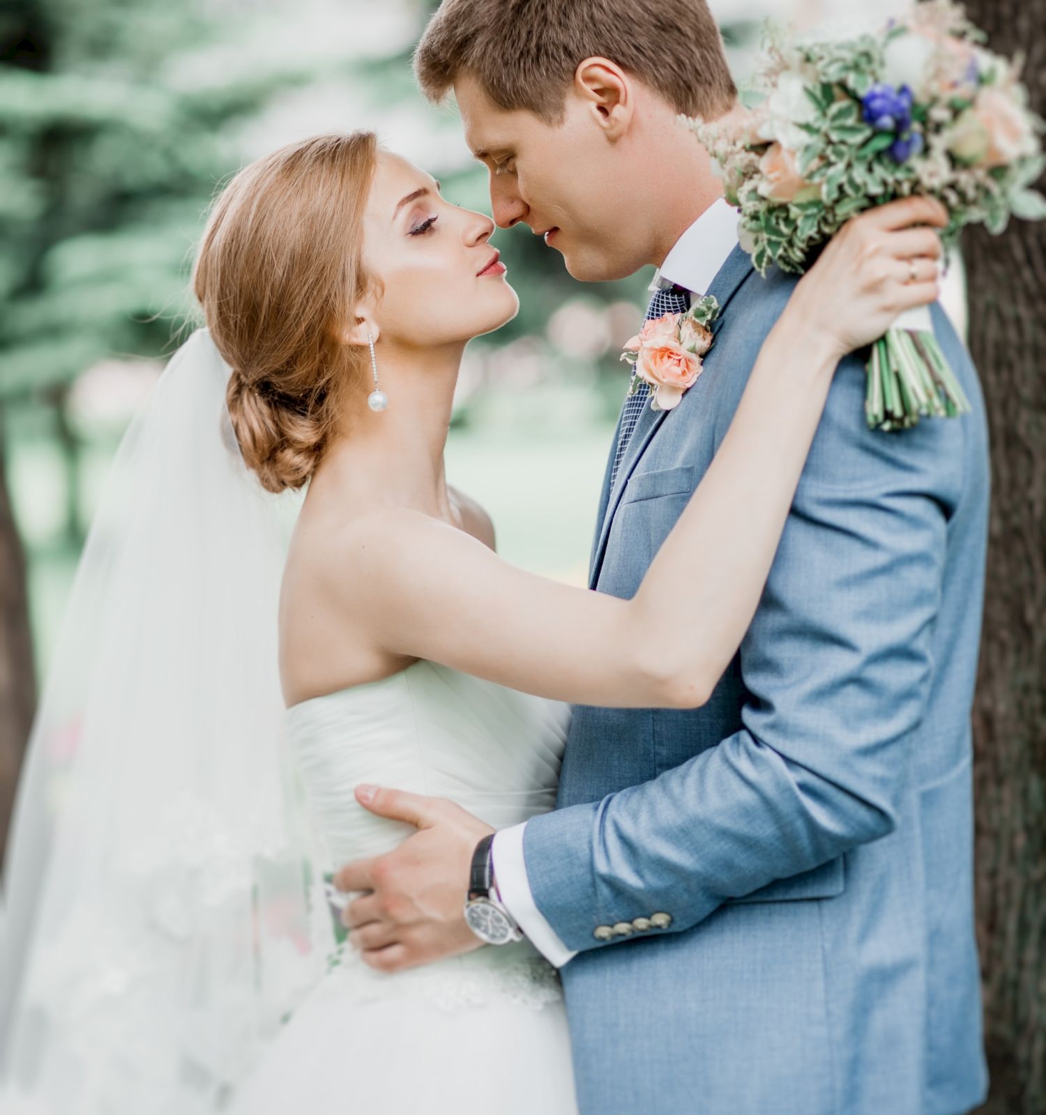 A bride and groom embrace, surrounded by greenery in Hotel Columbia Telluride.